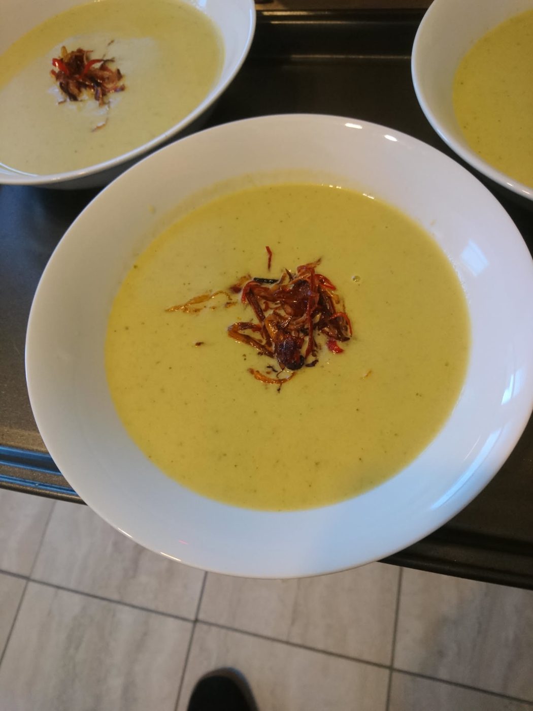 Velouté jaune garni d'échalotes frites et de piment